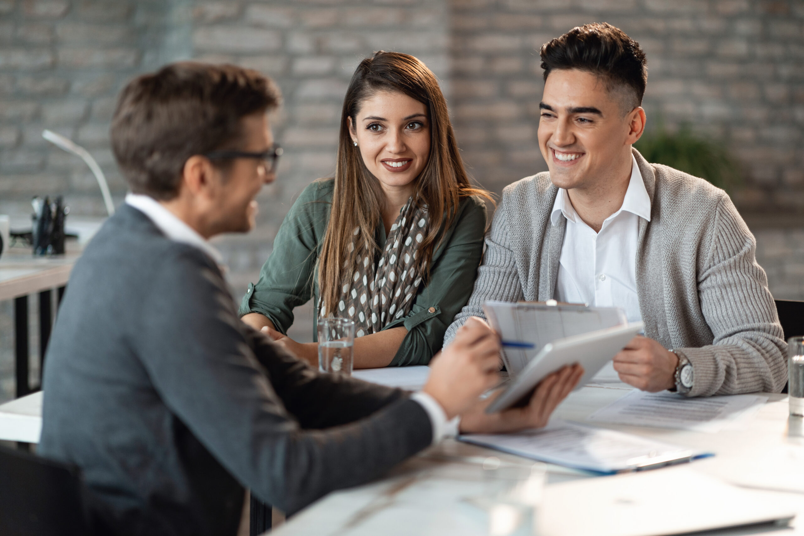 Young happy couple talking to their financial consultant on a meeting in the office.